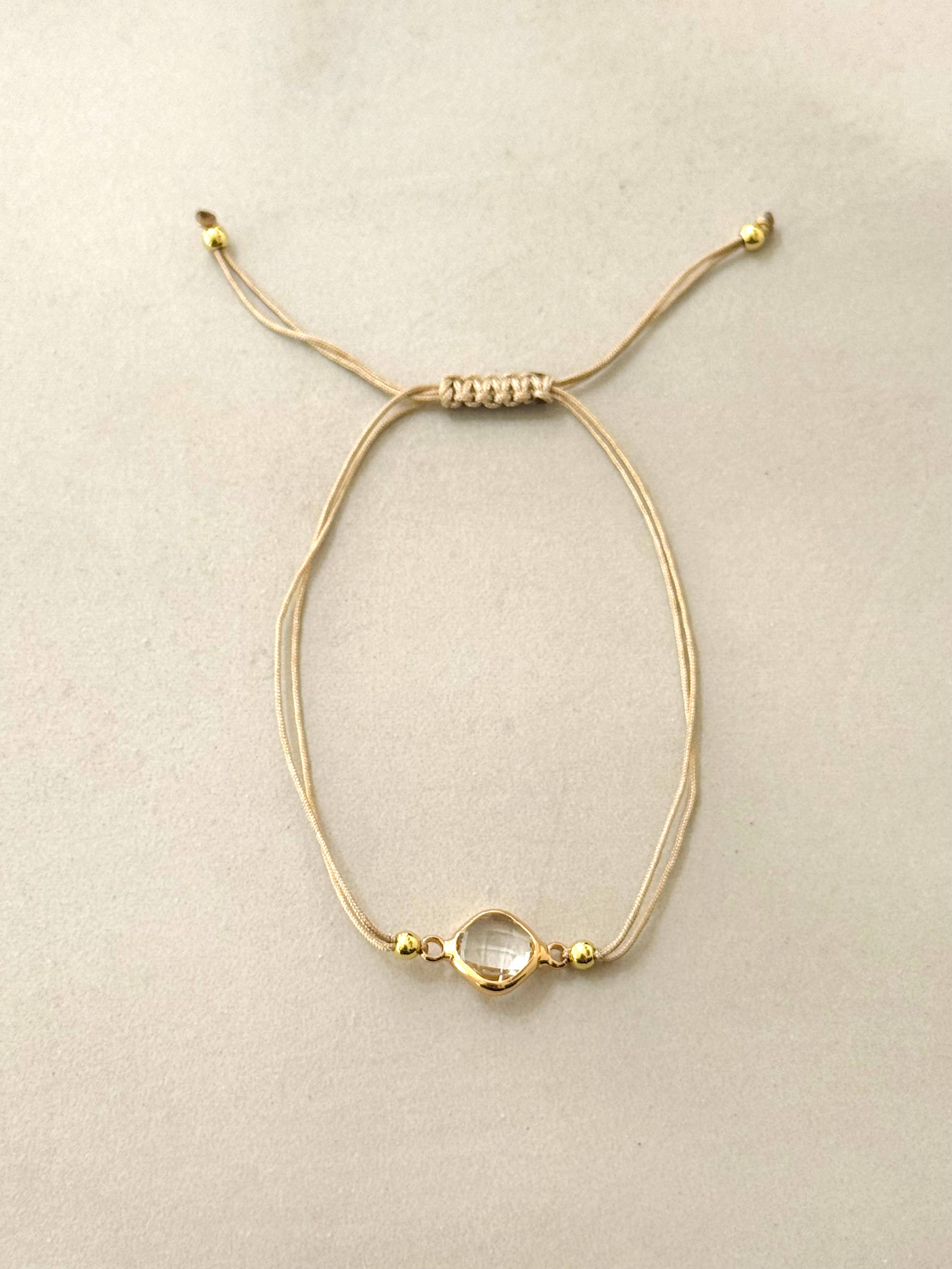 Pulsera Kala. Cuerda, acero inoxidable chapado en oro de 14 quilates y circonio.